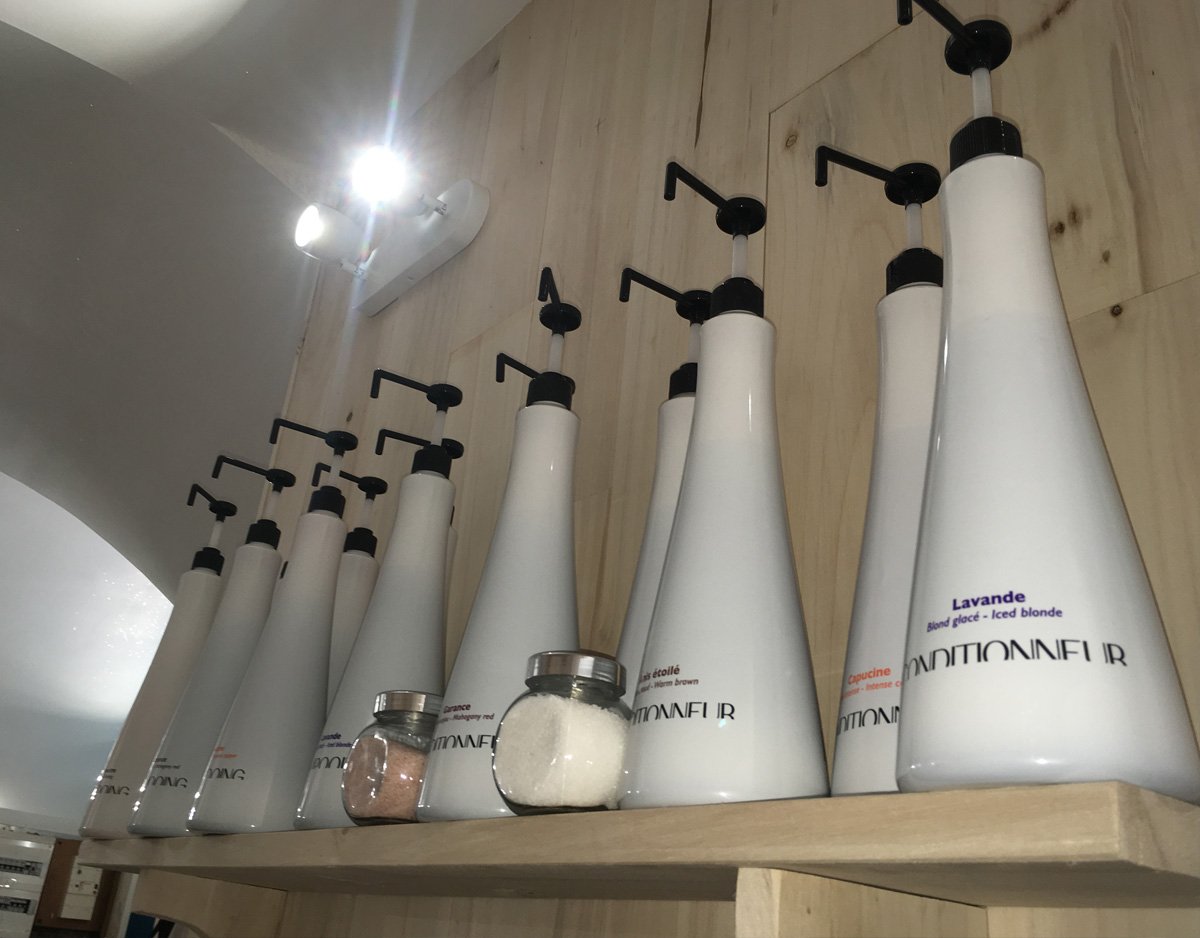 Flacons de shampoing suspendus sur une étagère en bois